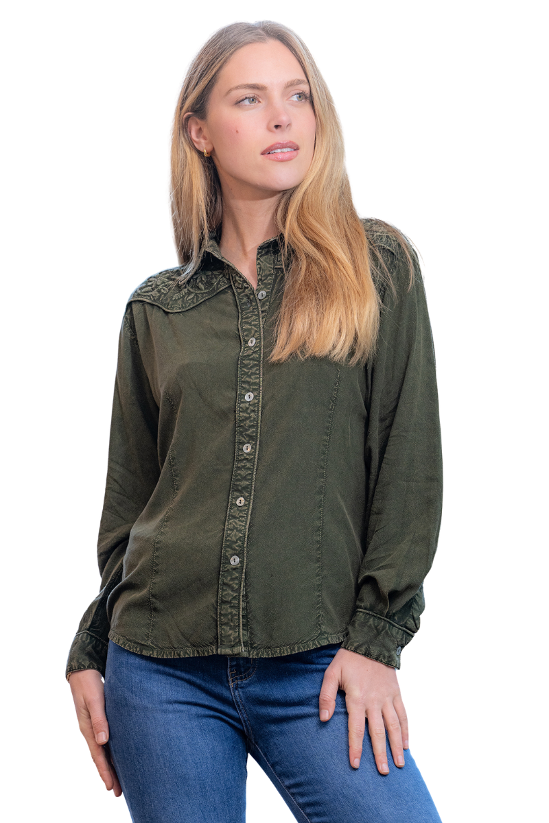 Woman wearing an olive green shirt and blue jeans on a white background