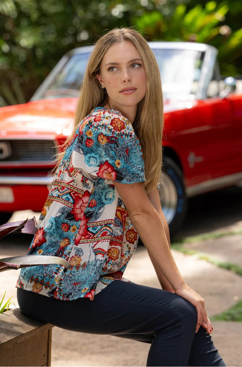 Woman seated in flare sleeve blouse.