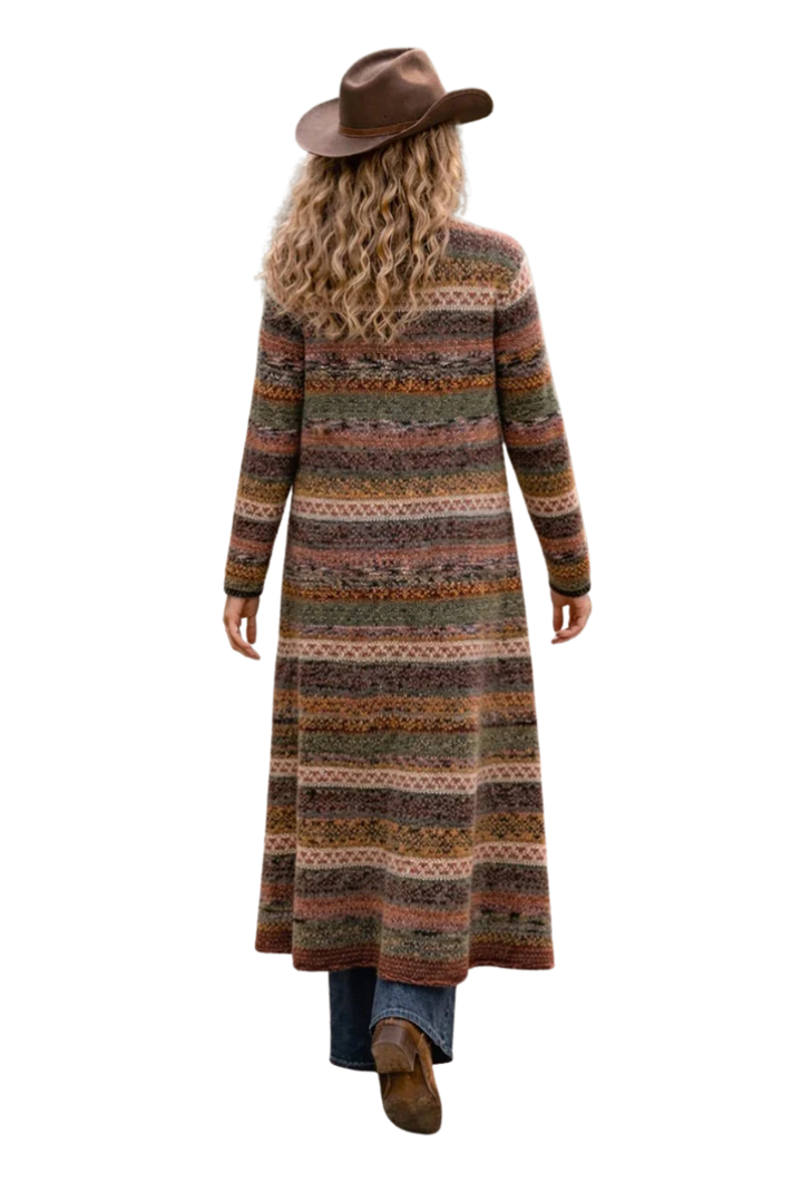 Person wearing a long, patterned cardigan with a white background