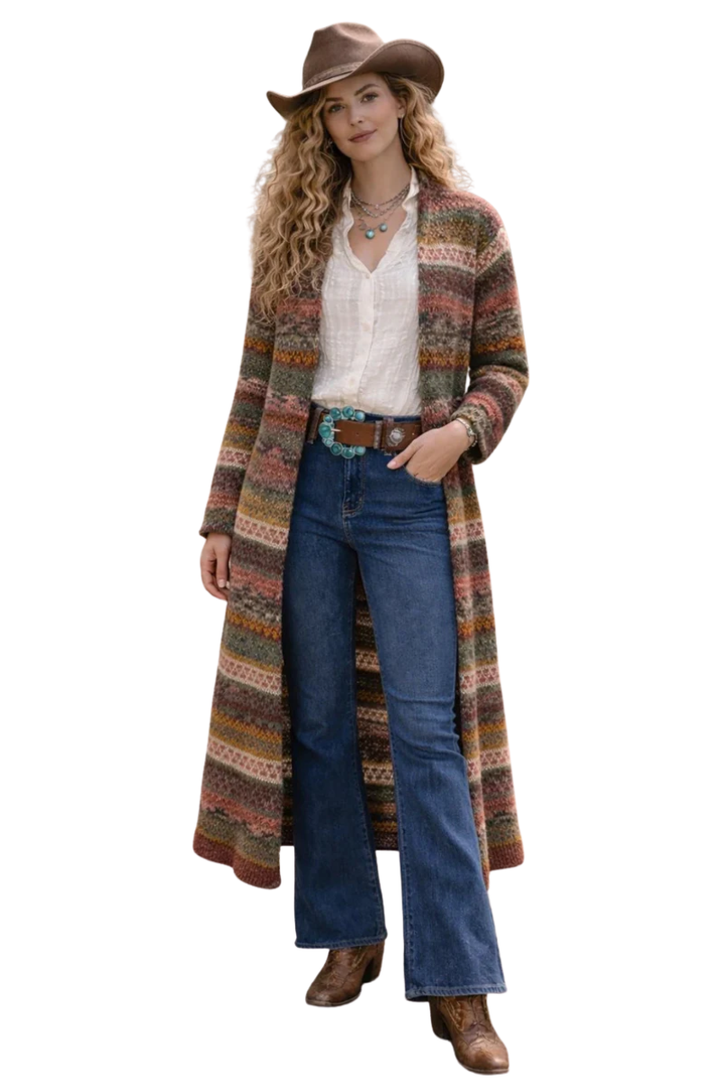Woman wearing a long, patterned cardigan, jeans, and a cowboy hat on a white background