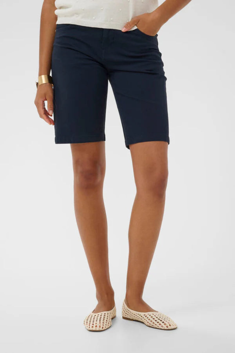 Person wearing navy shorts on a white background