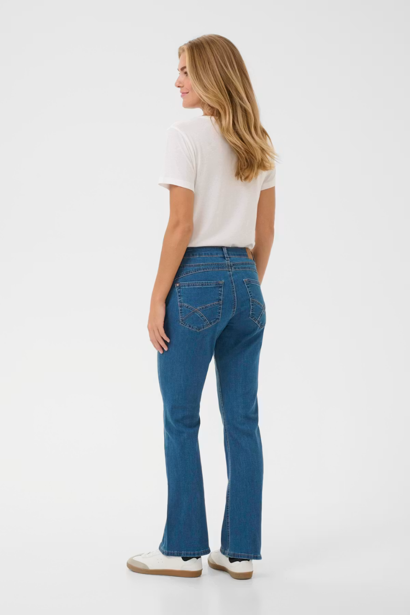 Woman wearing blue jeans and a white shirt on a white background