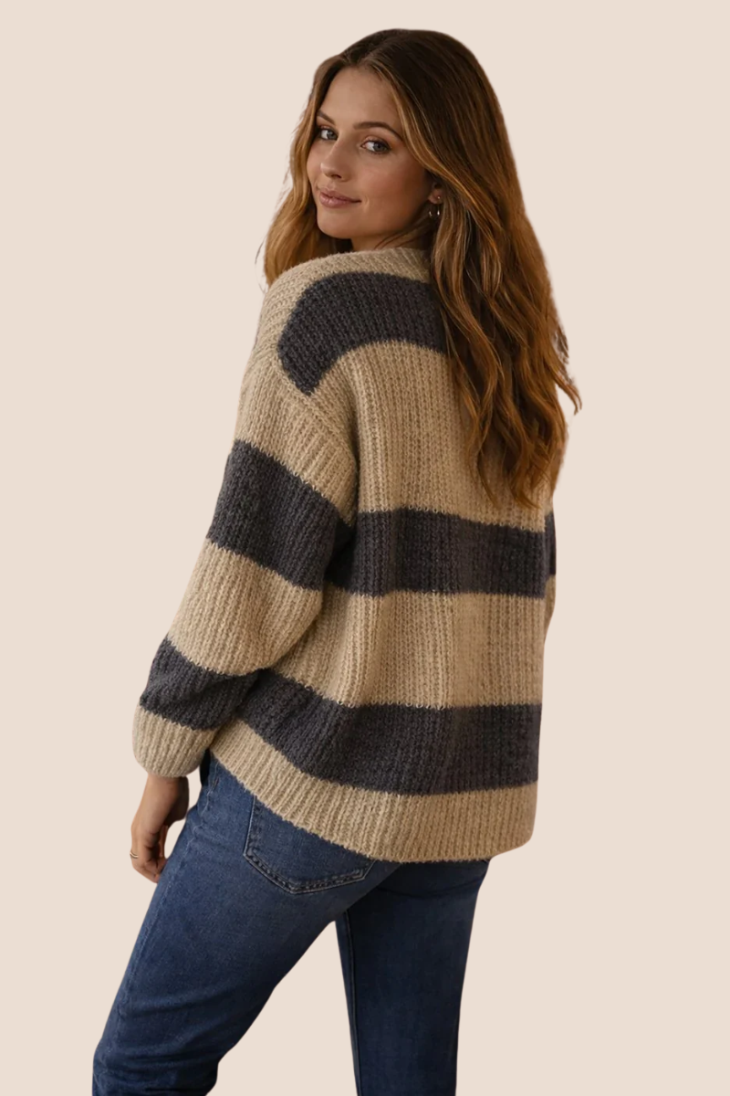 Woman wearing a striped sweater and jeans on a beige background