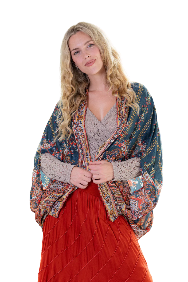 Woman wearing a patterned shawl over a red dress on a white background