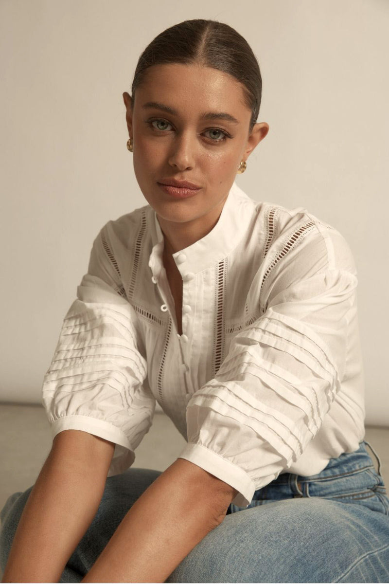 White textured blouse delicate ladder trim details, soft collarless neckline.