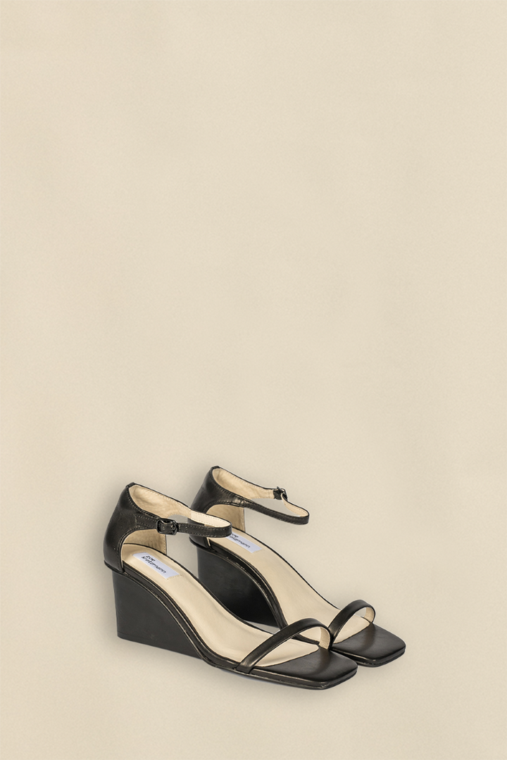 Side view of the Delight Wedge in Black, highlighting its elegant silhouette and sturdy wedge heel.