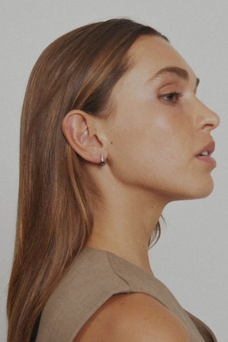 The Dolly Earrings in Silver by Zahar are shown worn on the model, highlighting their classic dome shape and polished finish for a timeless, elegant look — available at Ivy Vibe.
