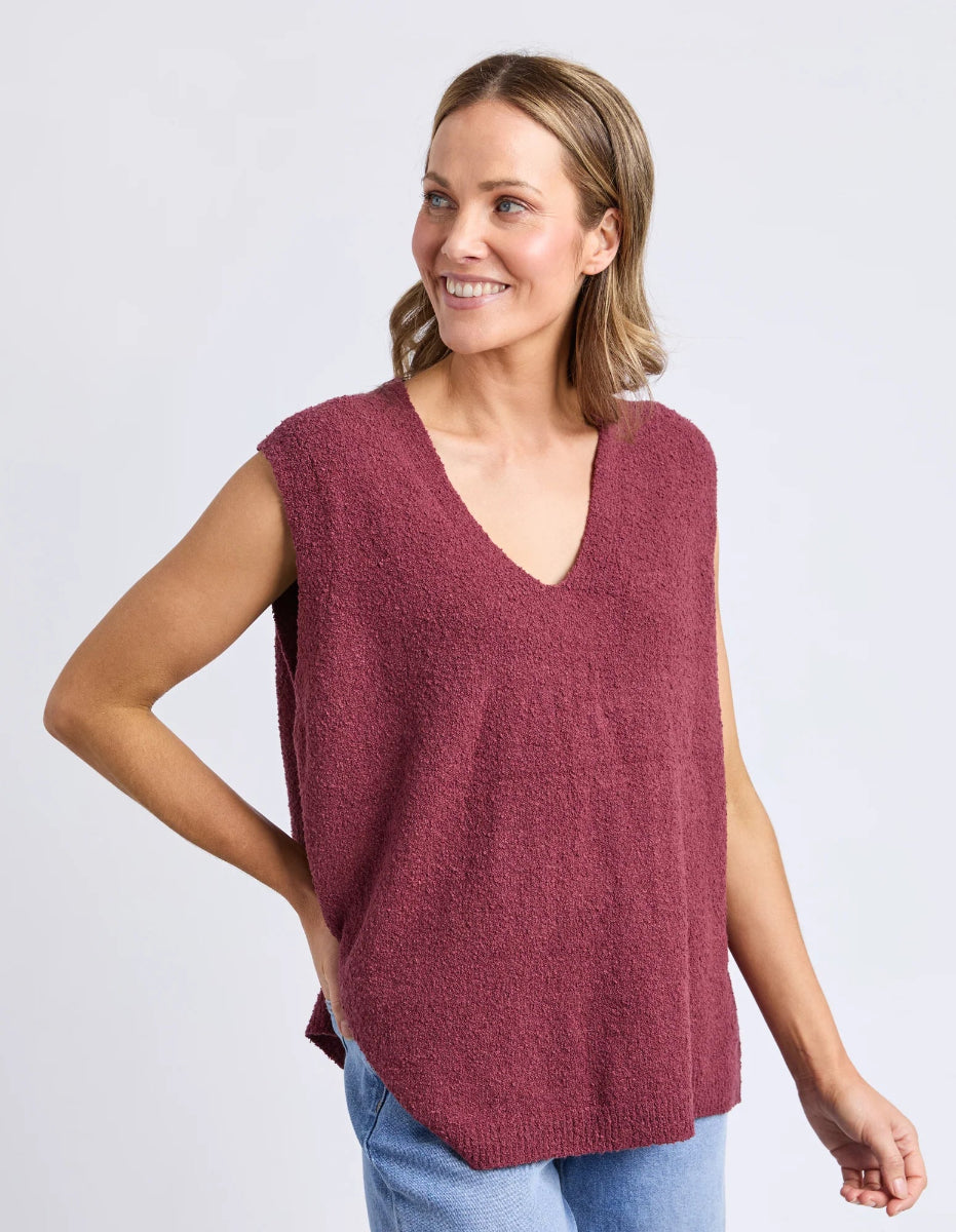 Model wearing plum sleeveless knit top with V neckline.