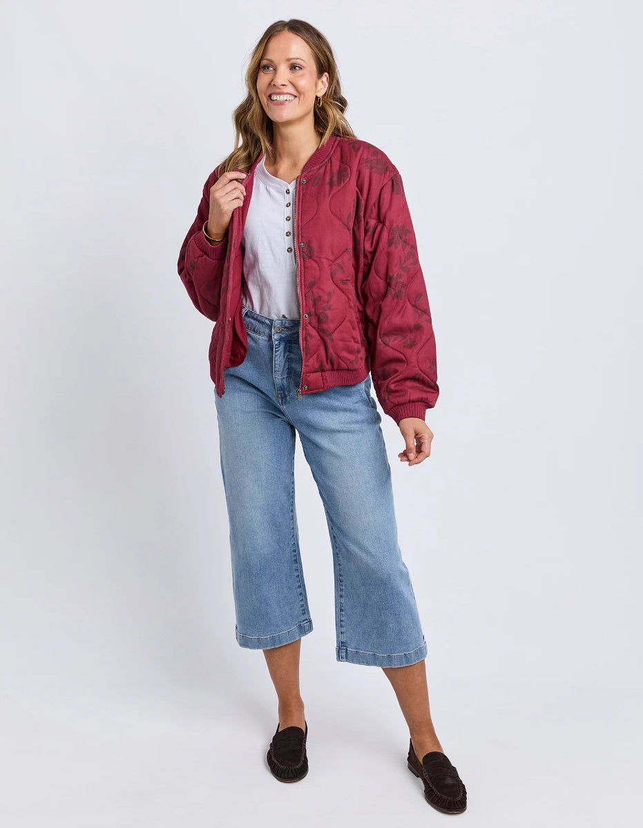 Woman wearing a red jacket and blue jeans on a white background