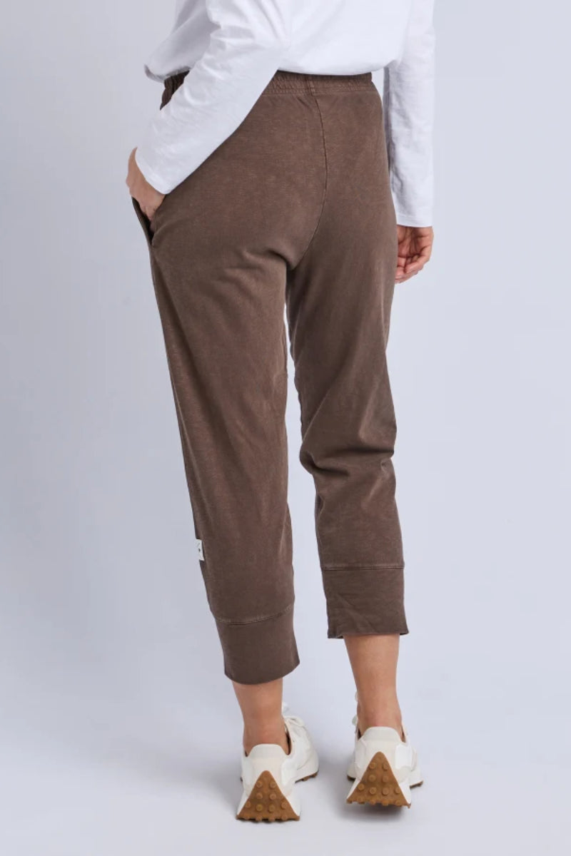 Brown pants worn by a person on a white background