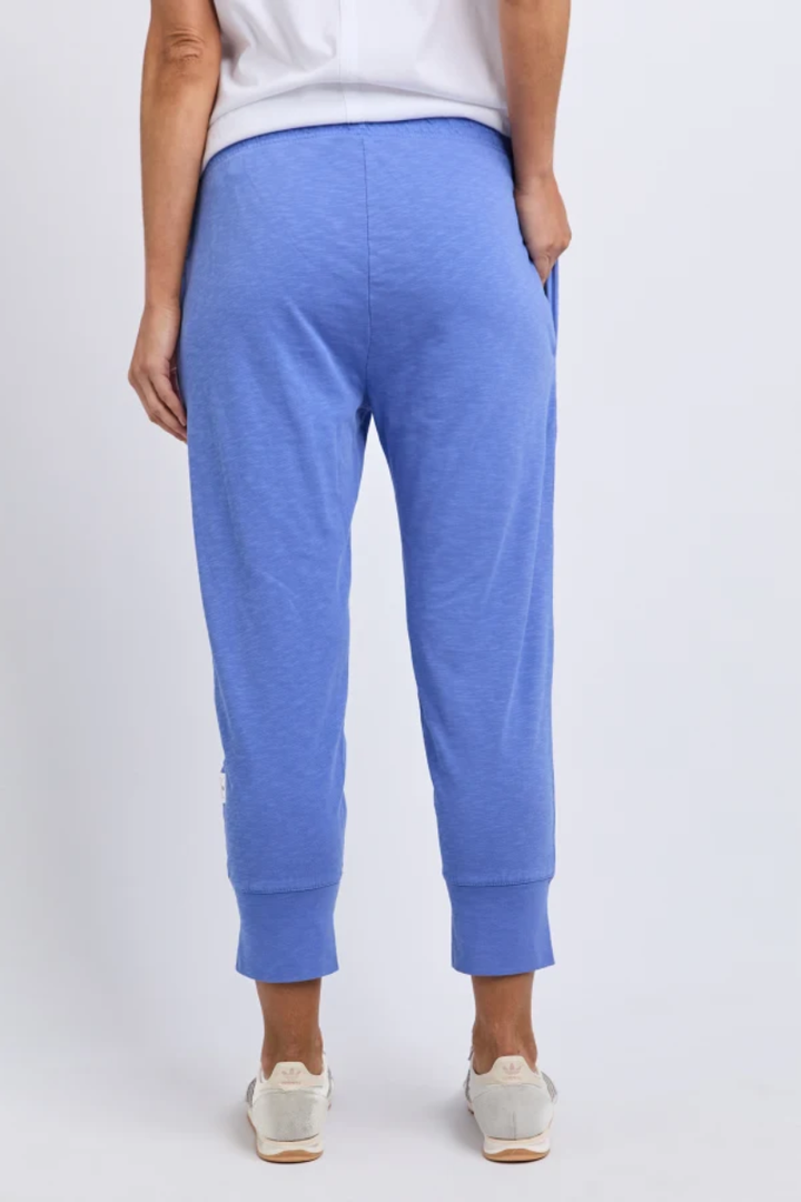Person wearing blue jogger pants on a white background