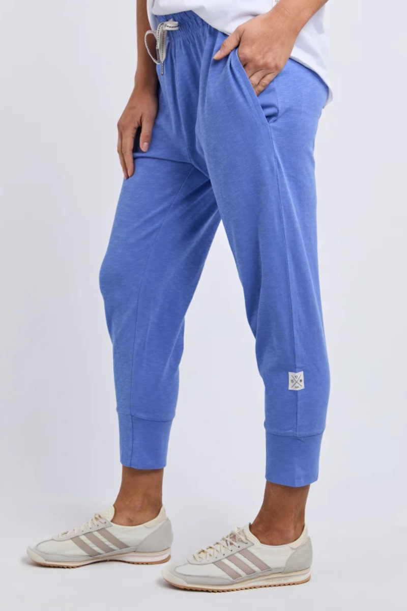 Person wearing blue jogger pants with a white background
