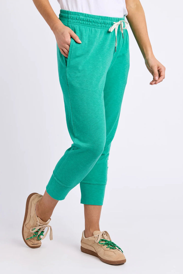Person wearing teal jogger pants on a white background