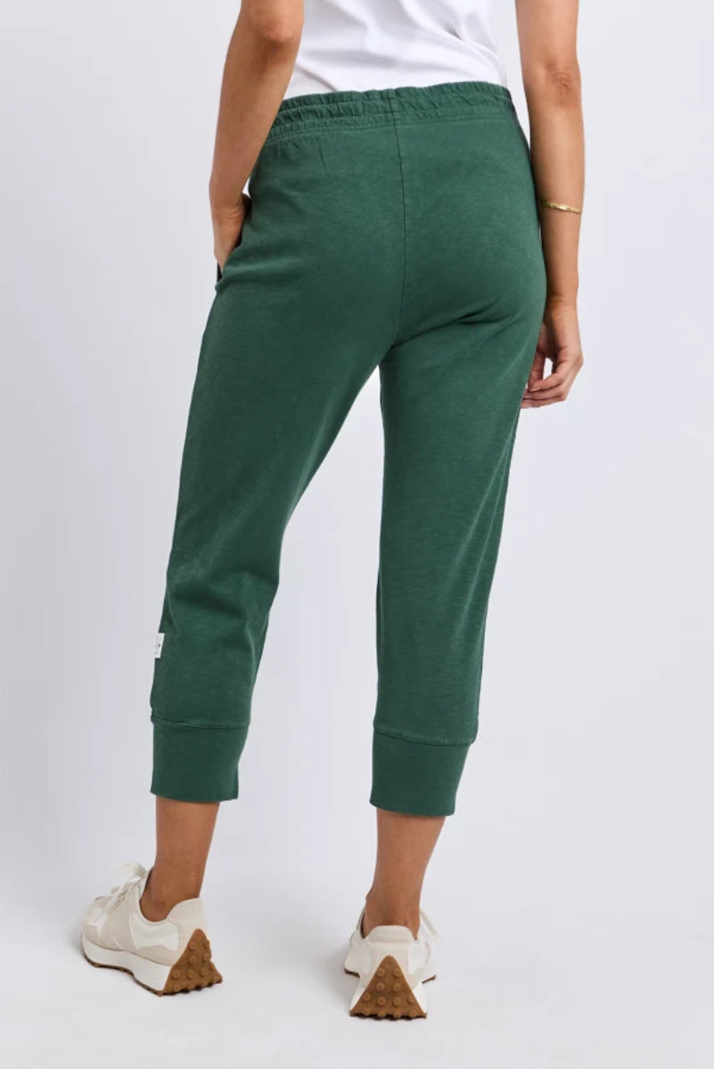 Green pants worn by a person on a white background