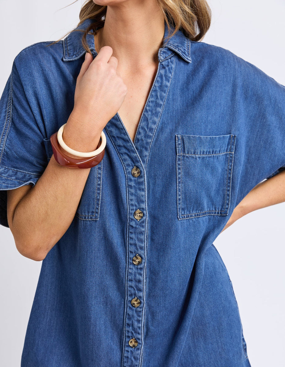 Close-up of blue denim button-front shirt dress.