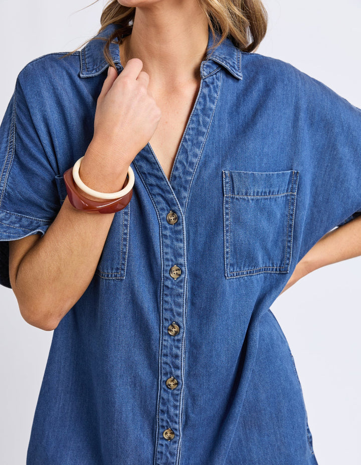 Close-up of blue denim button-front shirt dress.