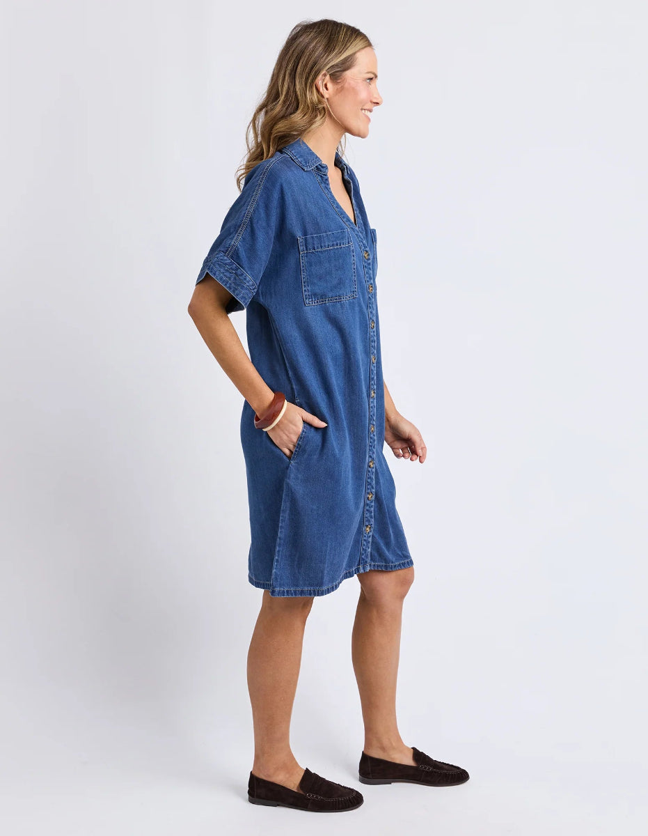 Side view of blue denim shirt dress with pockets.
