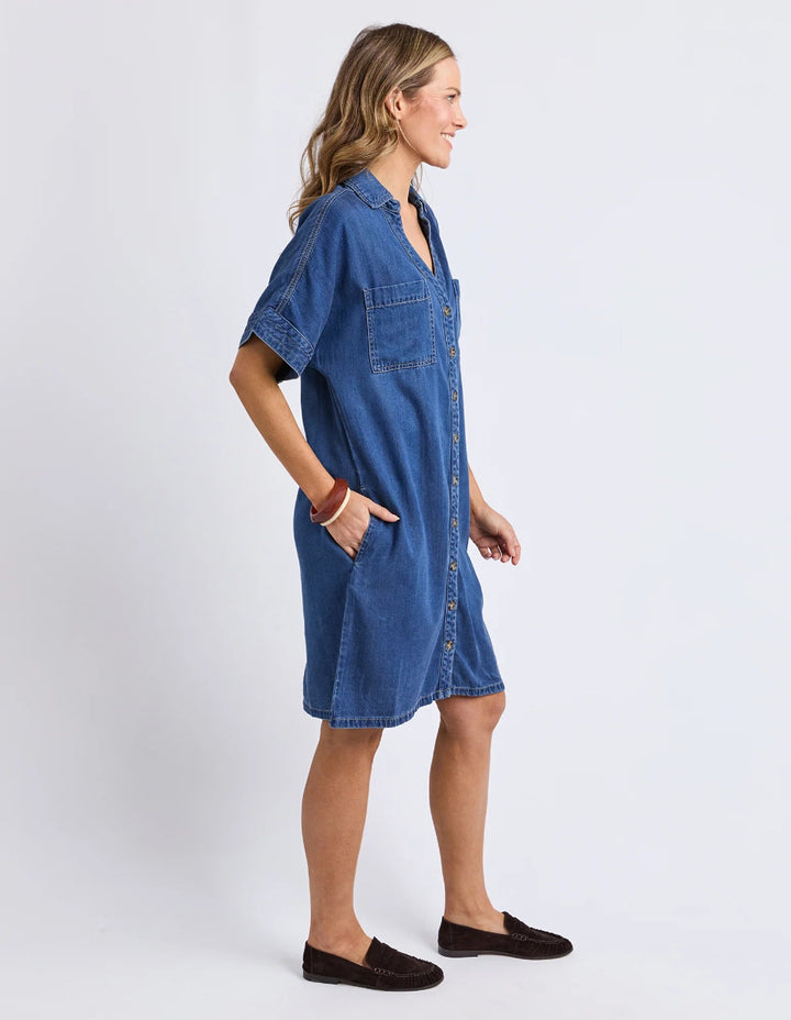 Side view of blue denim shirt dress with pockets.