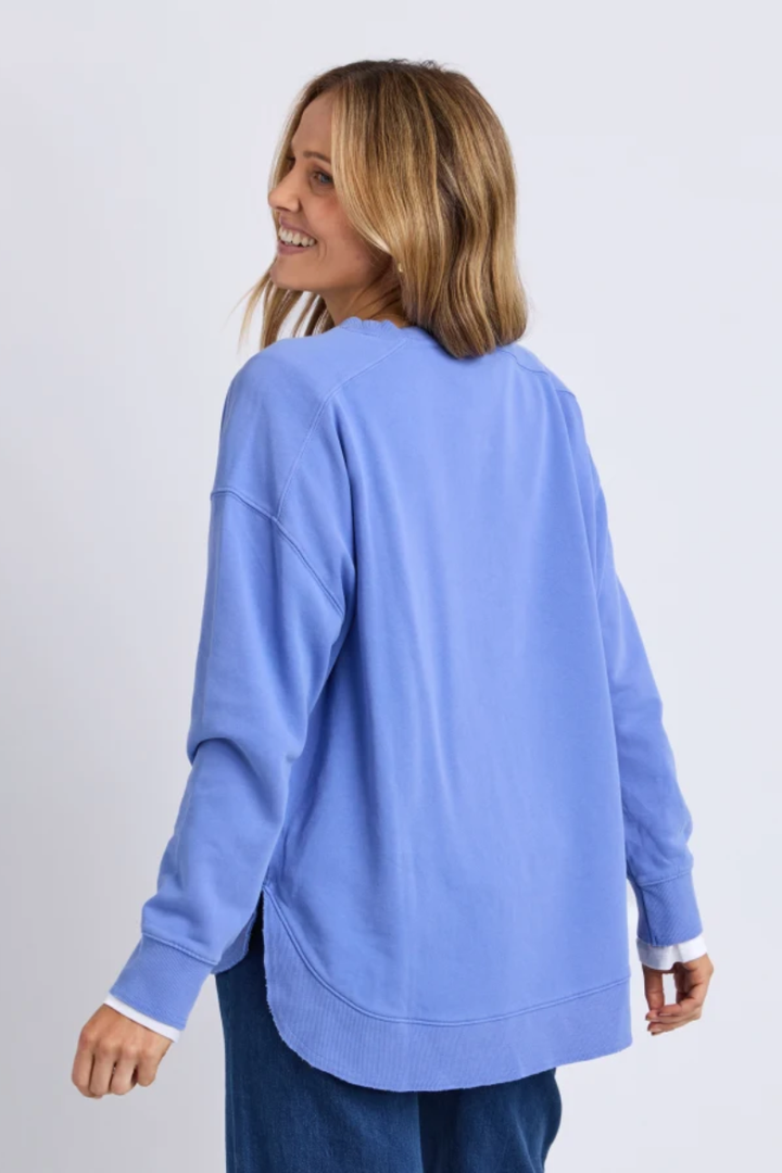 Woman wearing a light blue sweatshirt on a plain background