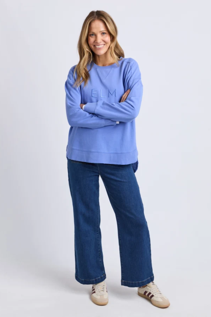 Woman wearing a blue sweatshirt and jeans on a white background