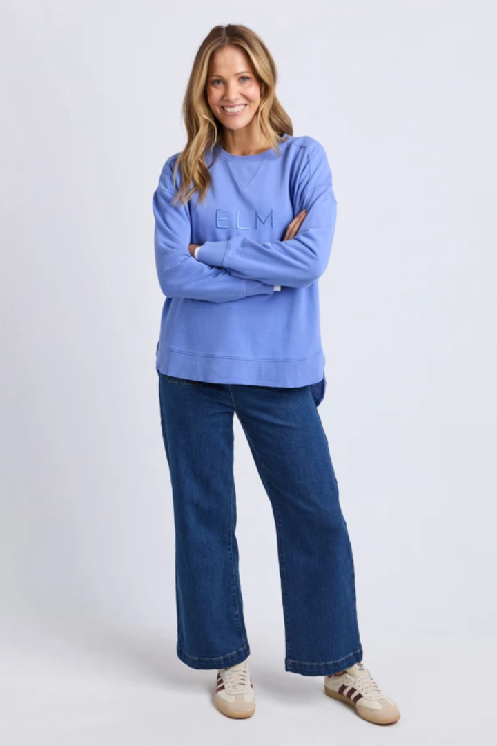 Woman wearing a blue sweatshirt and jeans on a white background