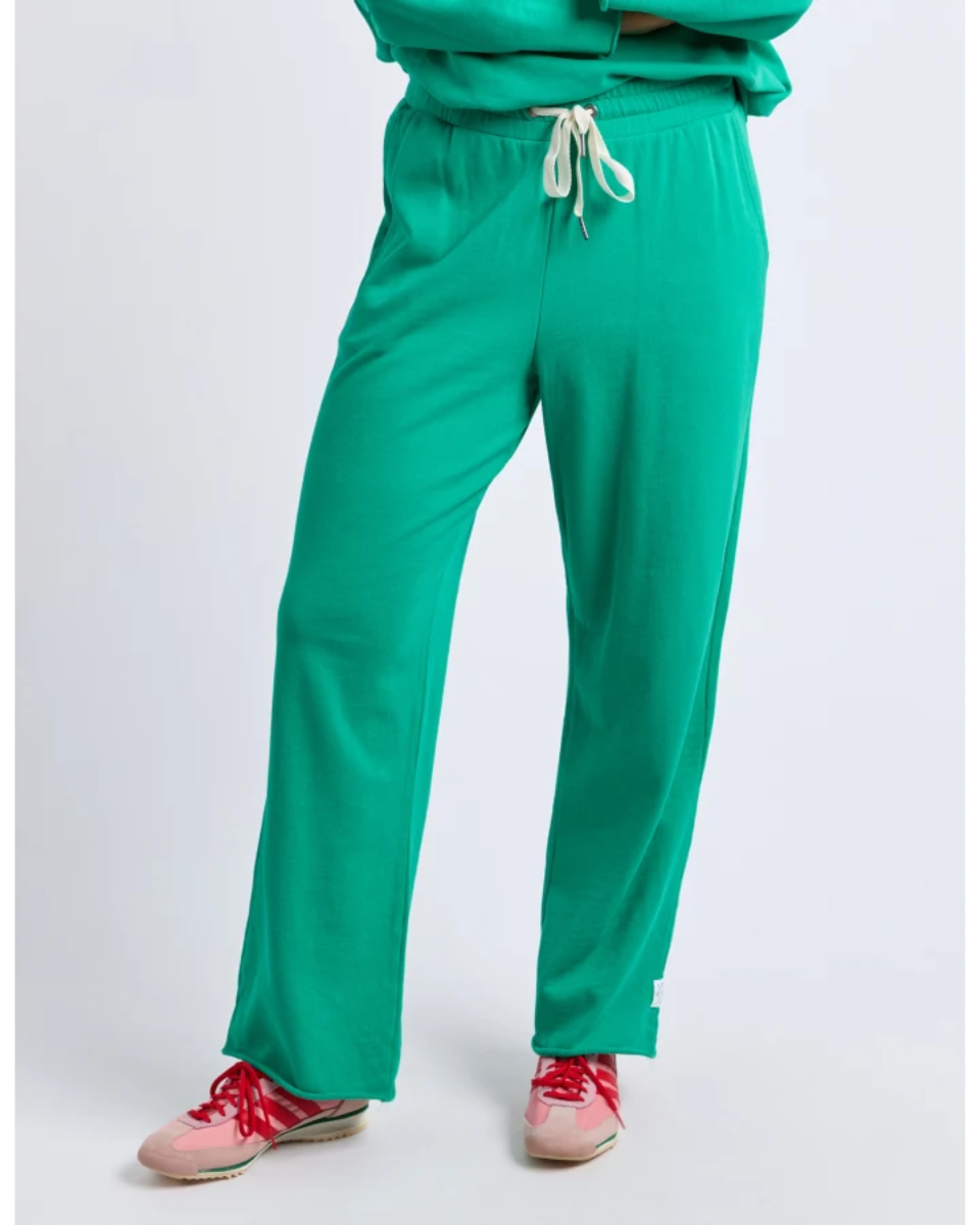 Green trackpants with pink shoes on a white background