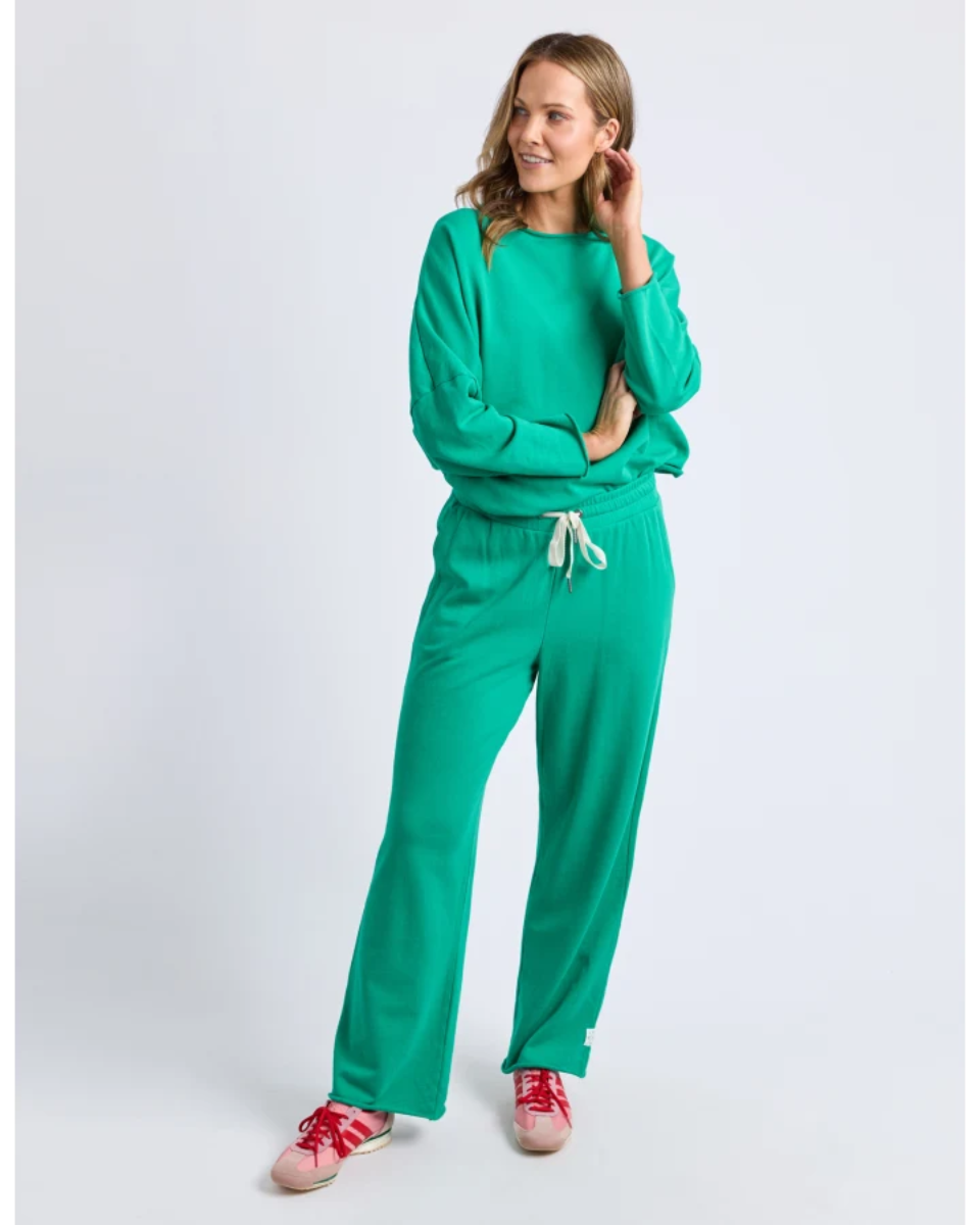 Woman wearing a green tracksuit on a white background