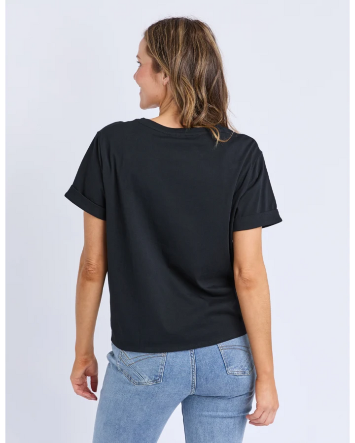 Person wearing a black t-shirt and light blue jeans on a white background