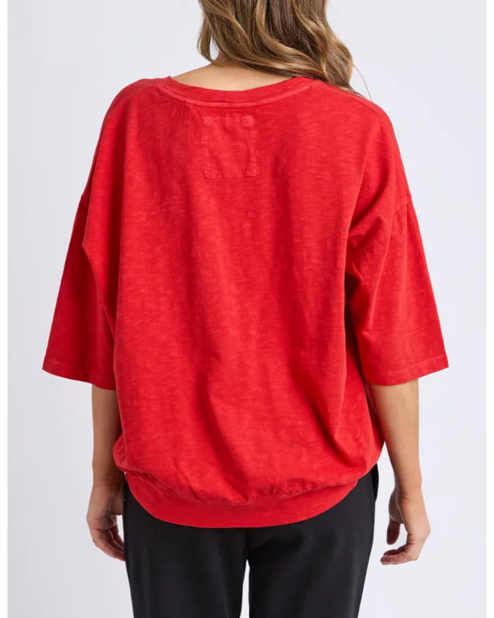 Red top worn by a person on a white background