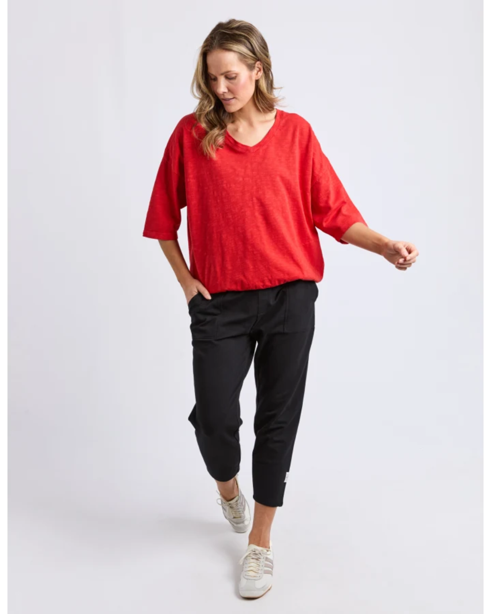 Front view of red V-neck short-sleeve top with black pants.