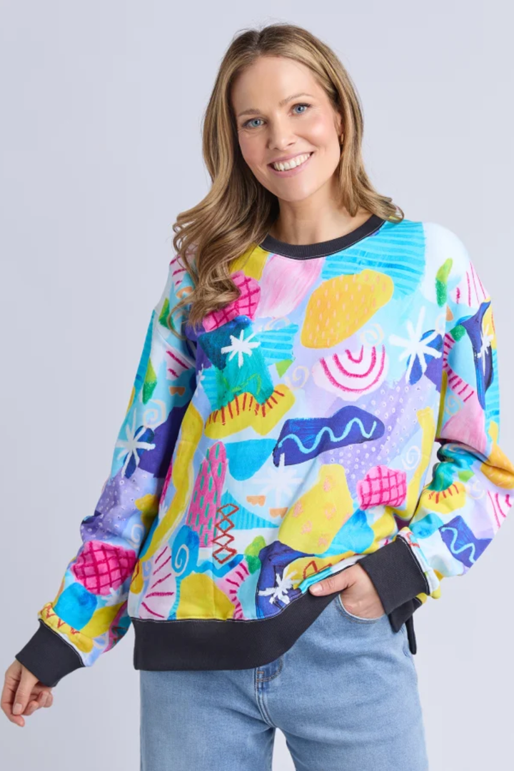 Woman wearing a colorful patterned sweater against a plain background