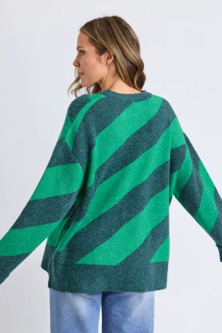 Woman wearing a green and blue striped sweater on a white background