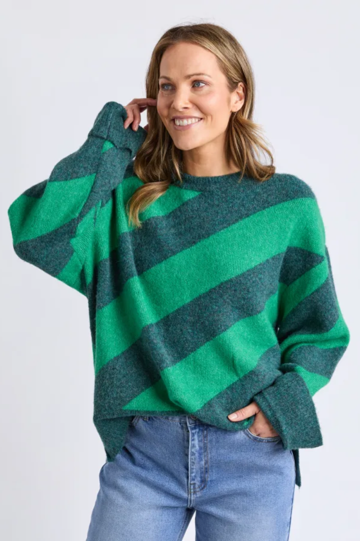 Woman wearing a green and blue striped sweater against a white background