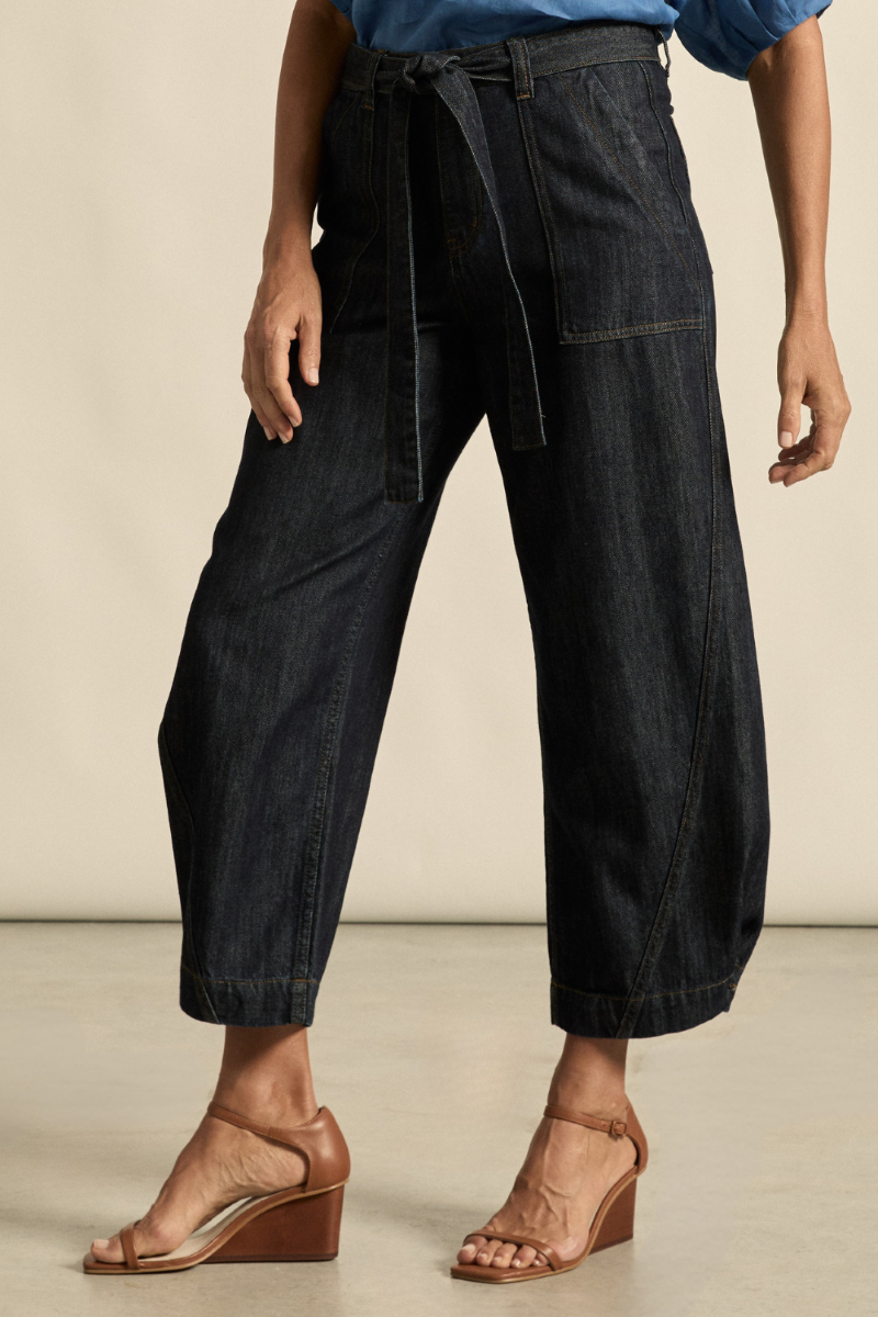 This side view of the Embark Jean in dark denim showcases its flattering fit, clean lines, and classic silhouette, available at Ivy Vibe.
