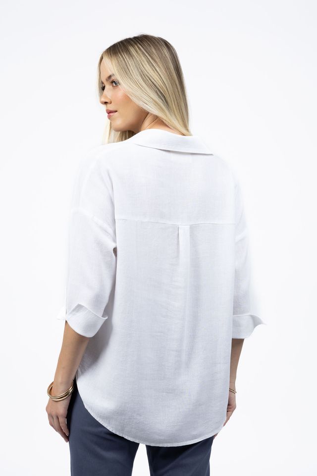 Woman wearing a white blouse with rolled-up sleeves on a white background