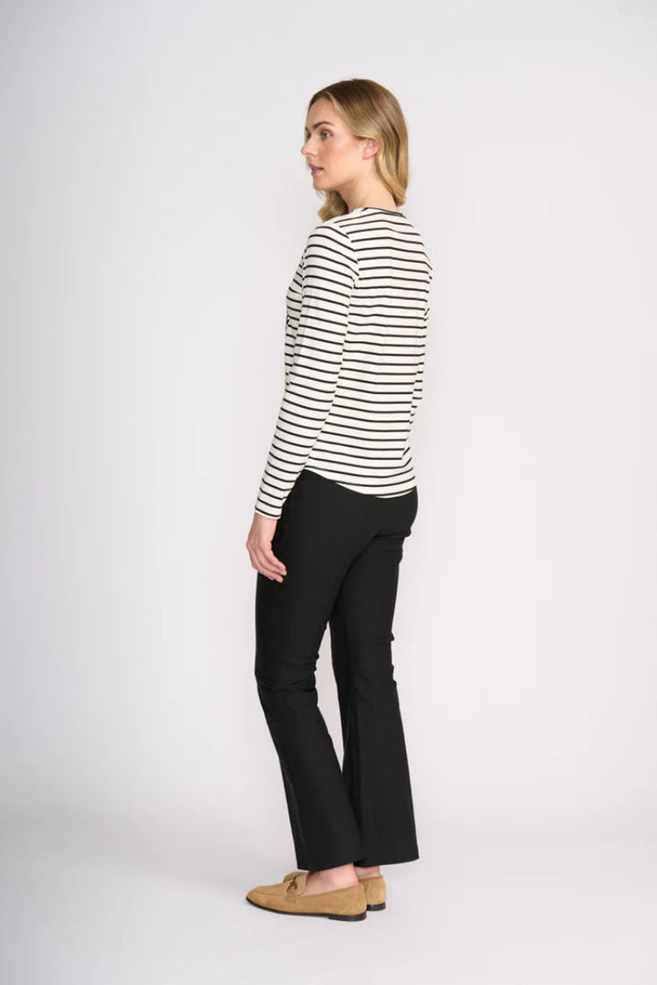 Woman wearing a black and white striped shirt and black pants on a white background
