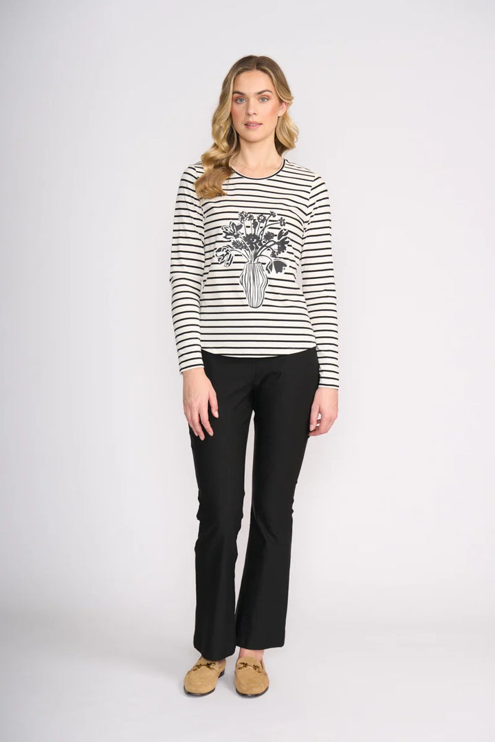 Woman wearing a black and white striped sweater with a graphic design on a white background