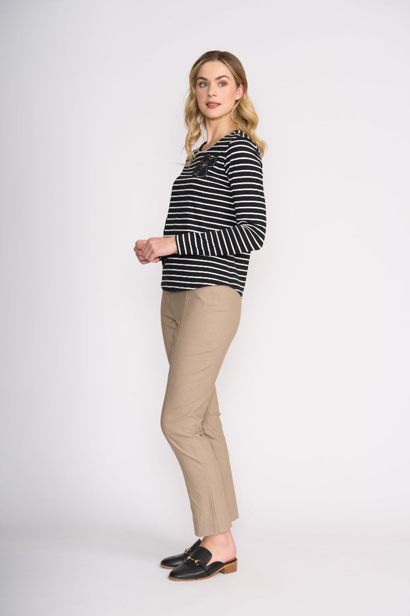 Woman wearing a striped sweater and beige pants on a white background