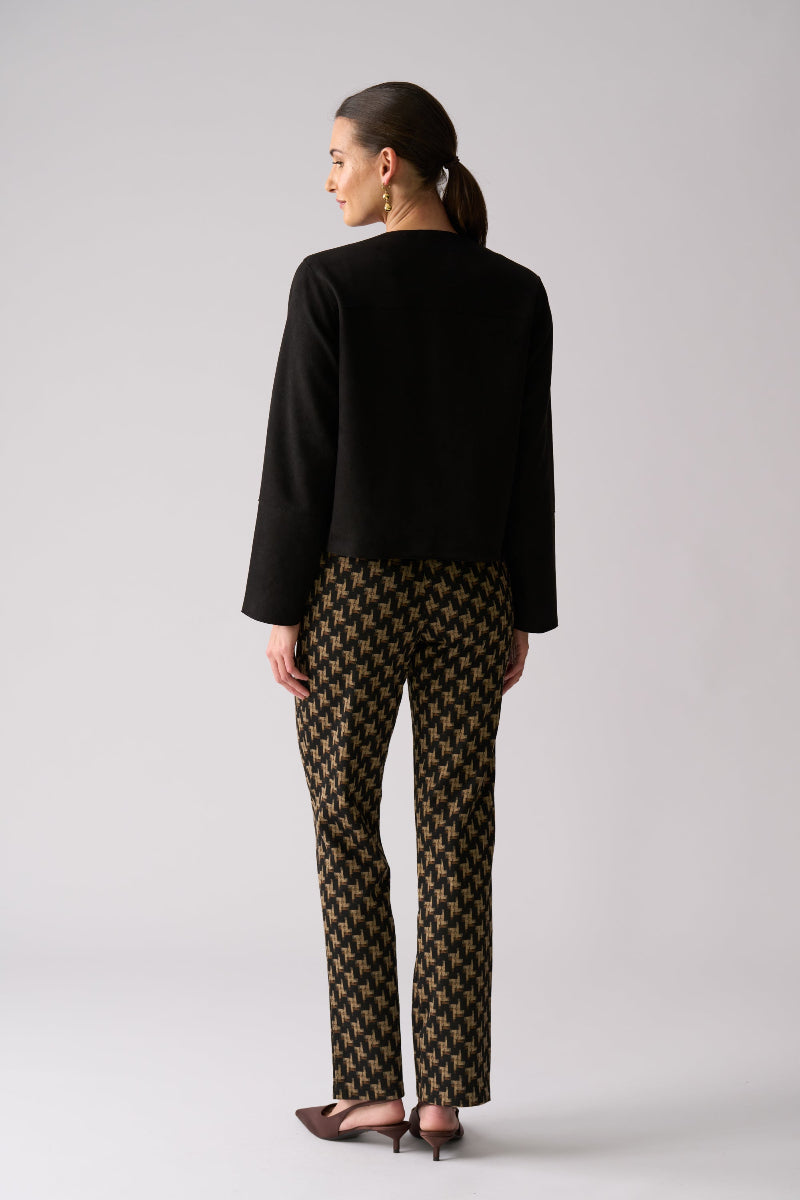 Woman wearing a black outfit with patterned pants on a white background