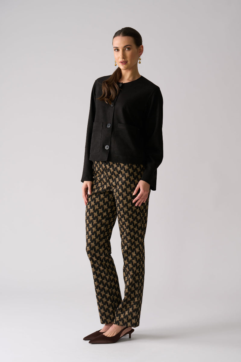Woman wearing a black outfit with patterned pants on a white background