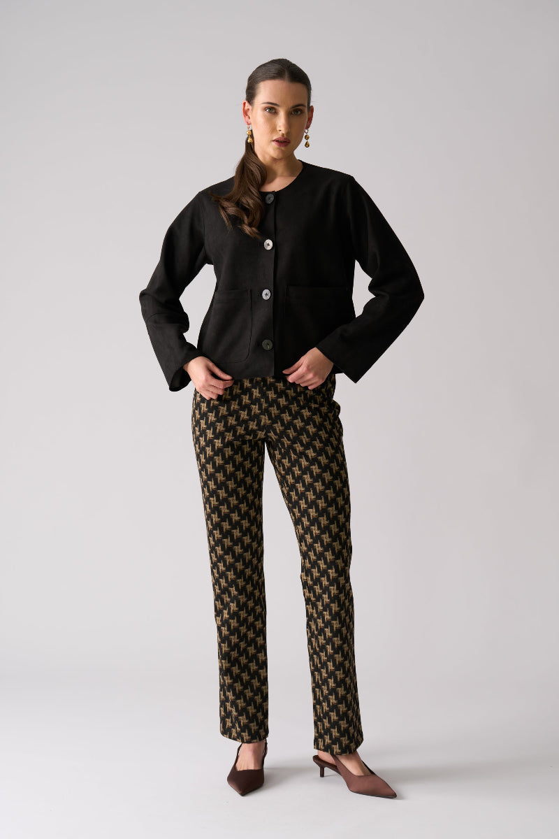 Woman wearing a black outfit with patterned pants on a white background