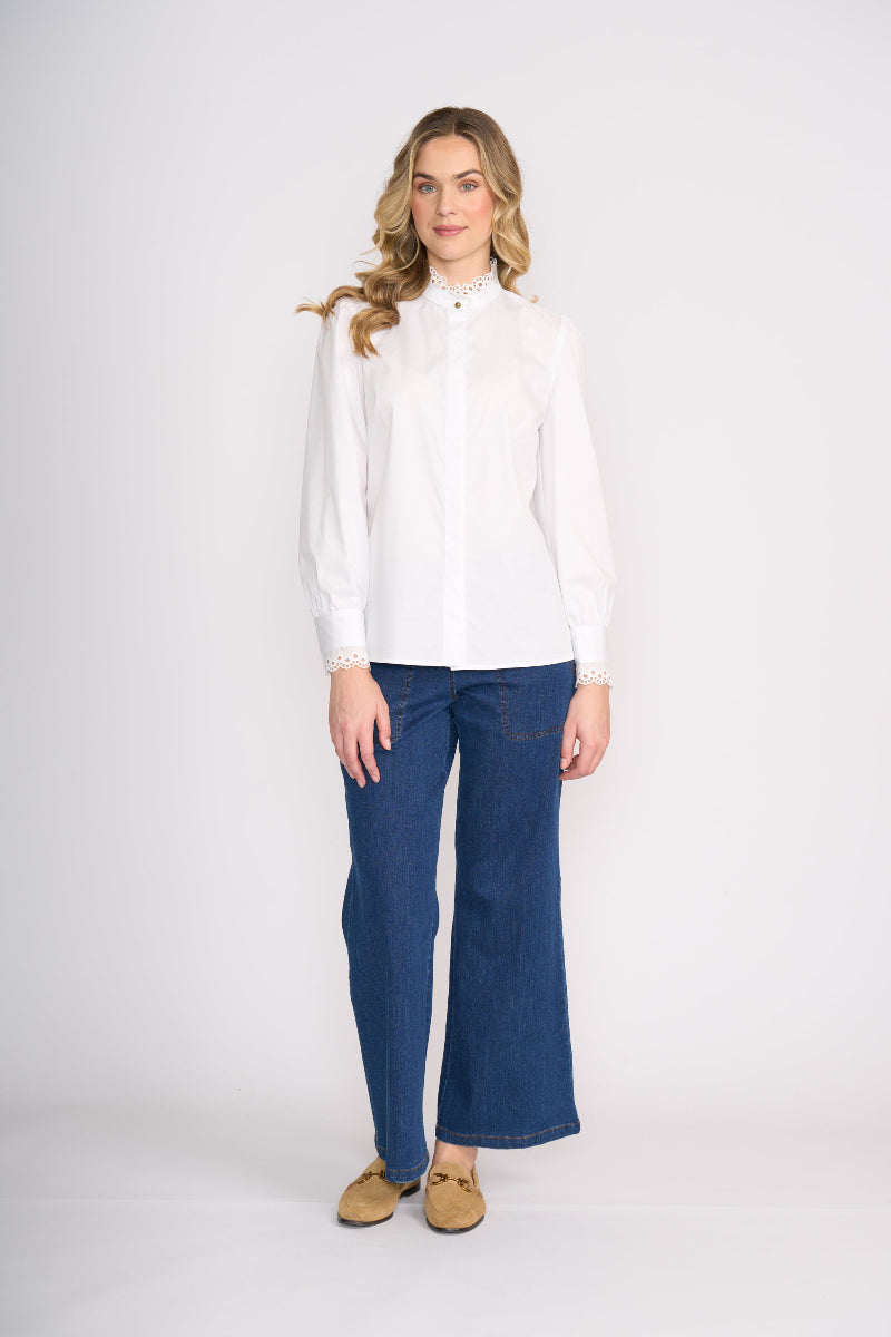 Woman wearing a white blouse and blue jeans on a white background