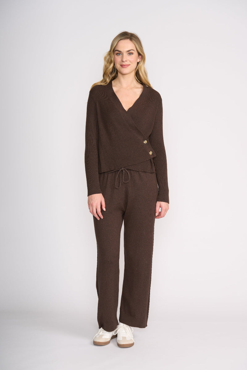 Woman wearing a brown outfit with a matching cardigan and pants on a white background