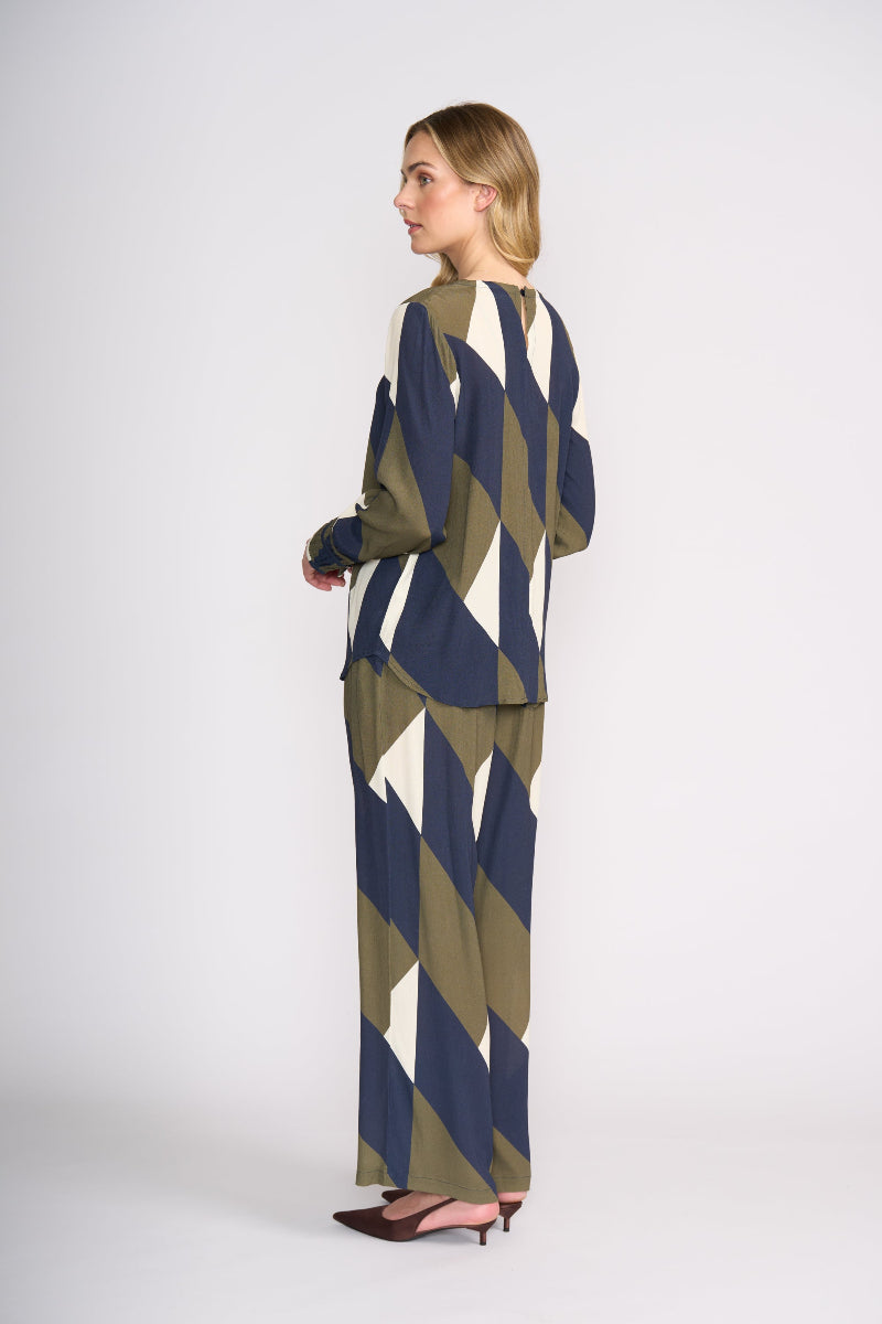 Woman wearing a geometric patterned outfit on a white background