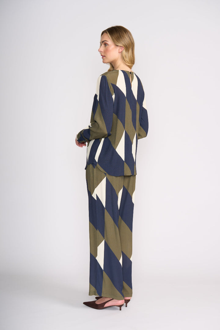 Woman wearing a geometric patterned outfit on a white background