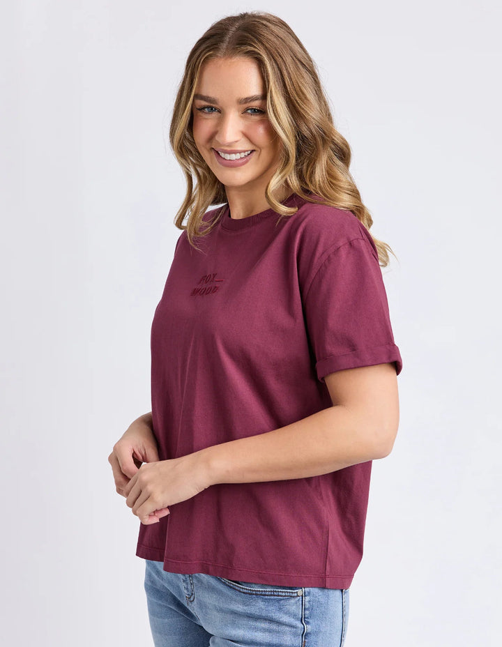 Wearing an oversized wine Tee short sleeves with Foxwood print in side view.