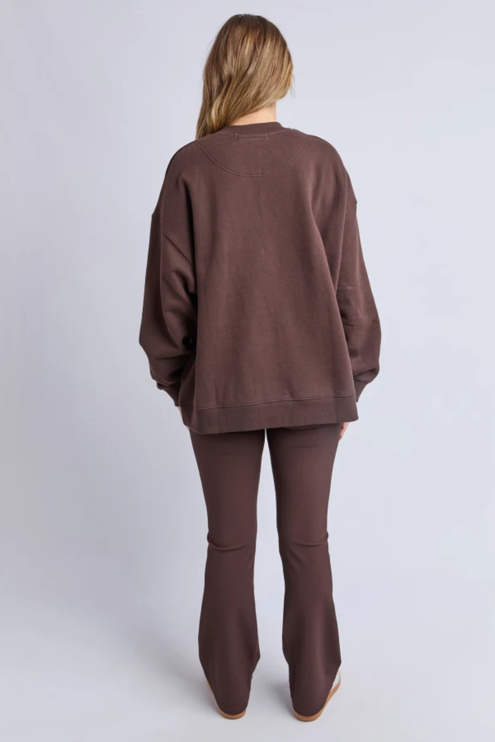 Person wearing a brown outfit with a sweater and pants on a white background