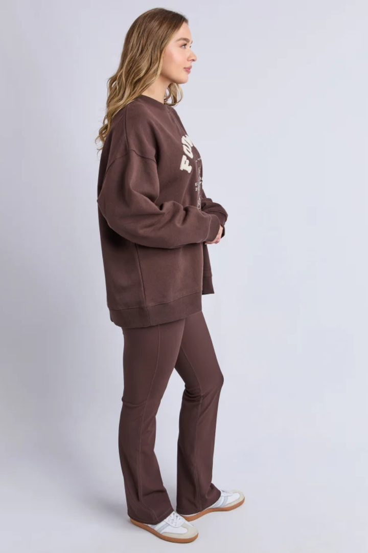 Woman wearing a brown tracksuit on a white background