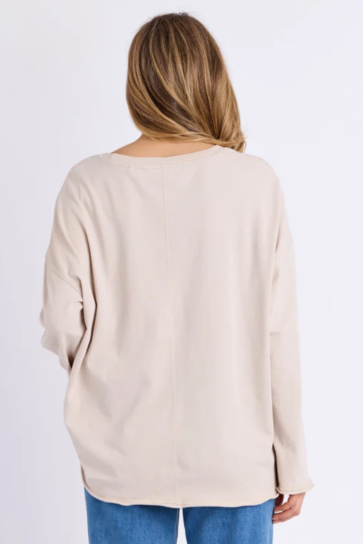 Beige sweater worn by a person on a white background