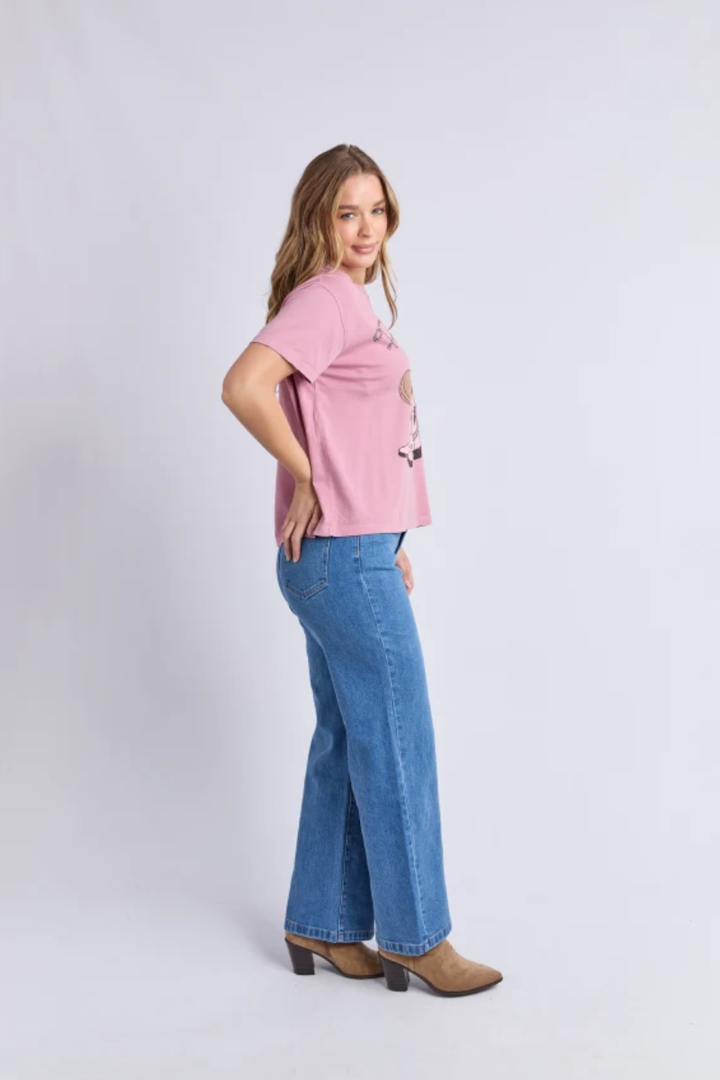 Woman wearing a pink top and blue jeans on a white background